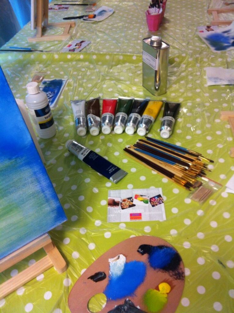 during a Bob Ross worshop; paint and other tools are laying on a table